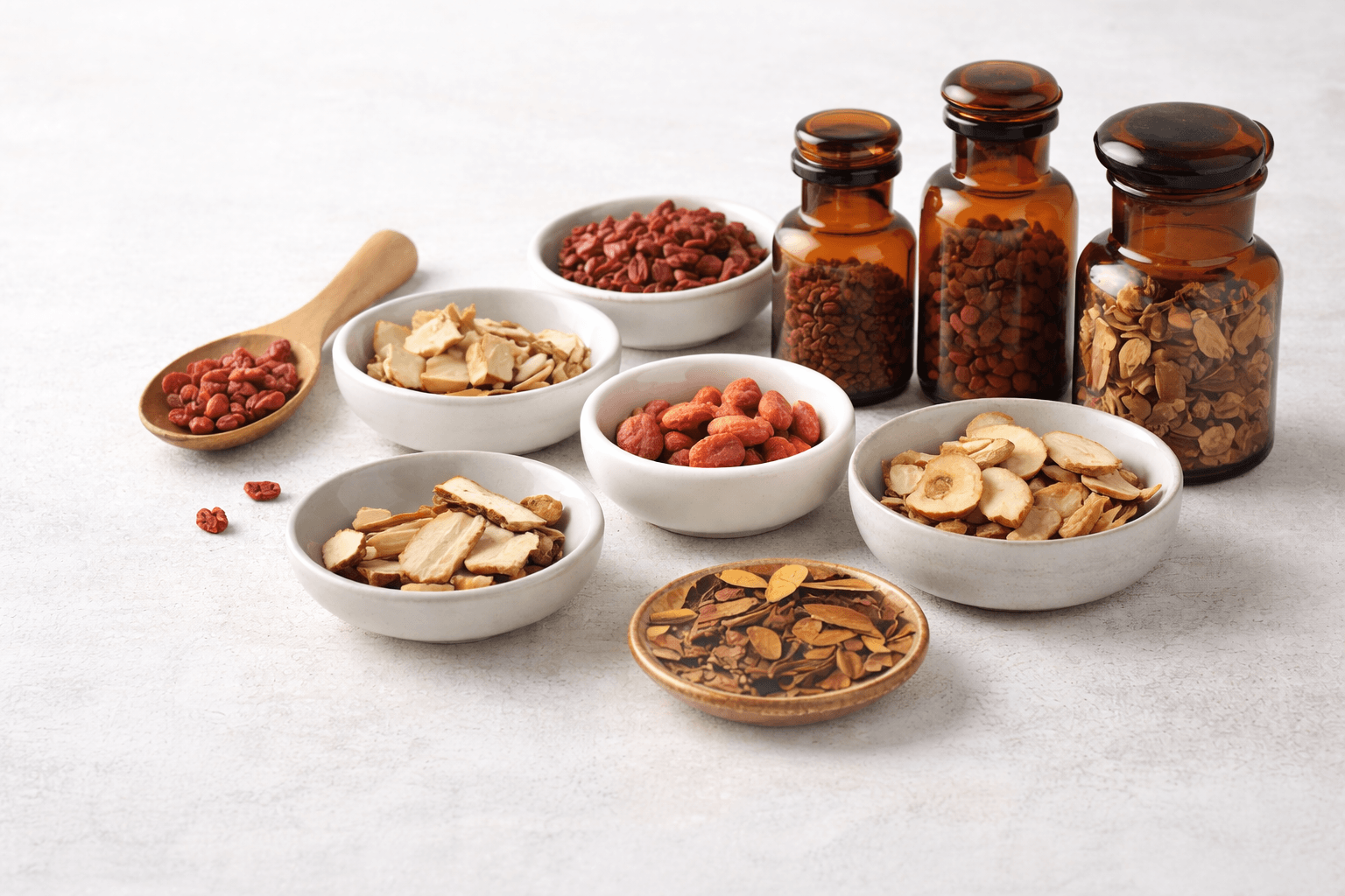 Herbal ingredients in bowls and bottles on a light background
